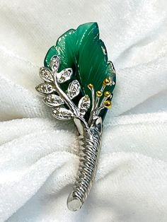 Be the envy of your friends with this stunning 925 Sterling Silver Brooch pin, a great find for a bride or a new bride-to-be. The gorgeous green onyx stone is beautifully carved as leaf Design and set in silver. Wear it as a brooch, as a saree pin, as a coat pin, or as a collar pin to enhance your personal Carved Leaf Design Green Onyx Brooch Pin Studded with Natural Diamonds in 925 Sterling silver. Design Inspiration is a floral leaf pattern. This piece is handcrafted by an old Artisan and it t Luxury Green Brooch For Anniversary, Luxury Green Brooches For Anniversary, Saree Pin, Coat Pin, Ear Piece, Green Onyx Stone, Silver Brooch Pin, Collar Pin, Collar Pins