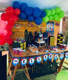 a table topped with lots of balloons and cake