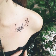 the back of a woman's shoulder with birds and flowers tattoo on her left side