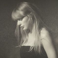 a black and white photo of a woman with long hair holding a cell phone in her hand