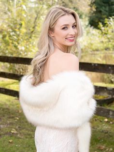 a woman wearing a white dress and fur stole