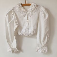 Such an adorable vintage 90's white cotton traditional Dirndl top with cotton crocheted collars and cuffs. It has puff sleeves. Size M Material:100% cotton Measurements: shoulder to shoulder:13,5" bust:19" length:14,5" Very good condition. Classic Cotton Tops With Peter Pan Collar, Cotton Tops With Lace Cuffs And Long Sleeves, Classic Cotton Top With Ruffled Collar, White Tops With Lace Cuffs And Ruffled Collar, Cotton Top With Ruffled Collar For Daywear, Classic Collared Tops With Lace Trim, Cottagecore Cotton Tops With Puff Sleeves, Fitted Cotton Shirt With Lace Trim, Vintage White Tops With Lace Trim