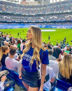 a woman standing in the stands at a baseball game