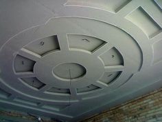 the ceiling is painted white and has circular designs on it, as well as brick walls