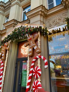 a giant gingerbread man is on display in front of a building with candy canes