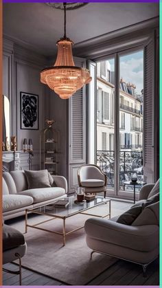 a living room filled with furniture and a chandelier hanging over the top of it