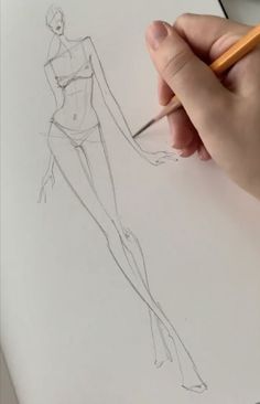 someone is drawing a woman's body on paper with a pencil in their hand