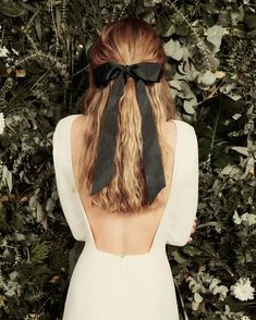 the back of a woman's head with a black bow in her hair and an instagram