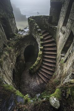 an old stone staircase with moss growing on the sides and steps leading up to it