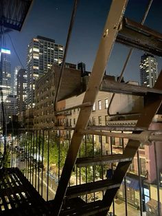 the city skyline is lit up at night with skyscrapers in the background, as seen from an elevated walkway