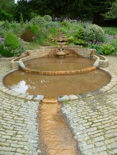 a water fountain in the middle of a garden