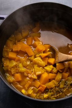 a pot full of stew with a wooden spoon