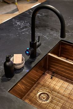 a kitchen sink that is under a faucet and some other items on the counter