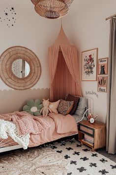 a bedroom decorated in pink and white with a canopy bed, star rugs, stars on the floor