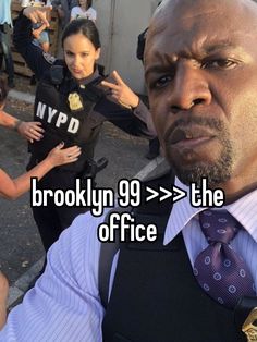 a man in a suit and tie with the words brooklyn 99 on his chest next to him