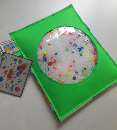 a green book with a paper plate filled with sprinkles next to it