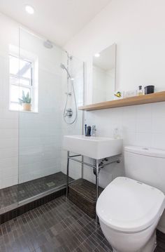 a white toilet sitting next to a walk in shower