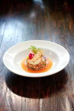 a white plate topped with food on top of a wooden table