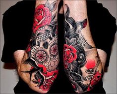 two tattooed hands with roses and skulls on them