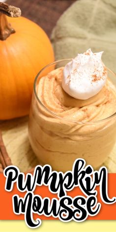 pumpkin mousse with whipped cream in a small glass bowl next to an orange pumpkin