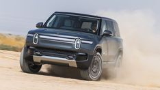 a black truck driving down a dirt road