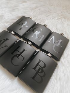 four black and white flasks with the letters b, f, m, d