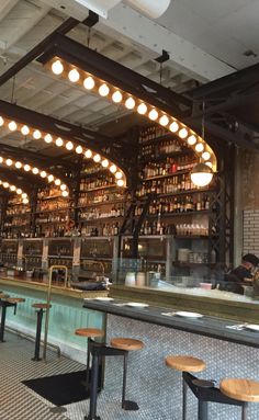 the inside of a restaurant with lots of tables and stools in front of it