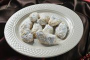 a white plate topped with pastries on top of a red cloth covered tablecloth