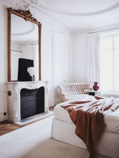 a bedroom with a bed, couch and fireplace in it's centerpieces