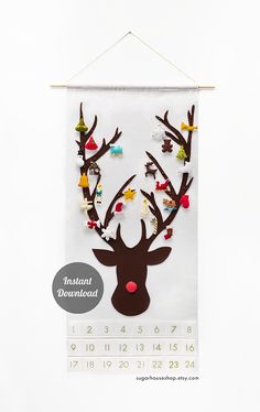 a calendar hanging on a wall with reindeer's head made out of paper and beads