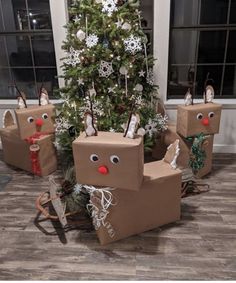 some brown boxes are sitting in front of a christmas tree with reindeer heads on them