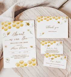 the wedding stationery is laid out on a table with honeycombs and bees