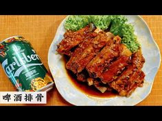 a white plate topped with meat and lettuce next to a can of beer