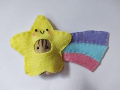 a small yellow star with a smiling face on it's side next to a pink and blue hair clip