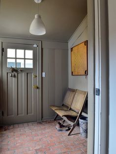 a wooden bench sitting in the middle of a room next to a door and window