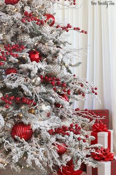 a white christmas tree with red and silver ornaments