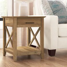 a small wooden table sitting on top of a hard wood floor next to a white couch