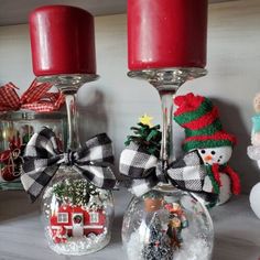 christmas decorations are displayed in glass balls on a shelf next to candles and other ornaments