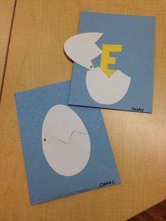 two pieces of paper cut out to look like an egg with the letter e on it