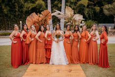 a group of women standing next to each other in front of a wooden table with flowers on it