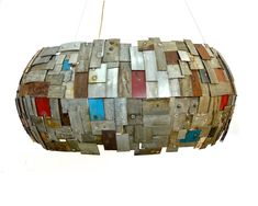 a light fixture made out of wooden planks and colored doors hanging from a ceiling