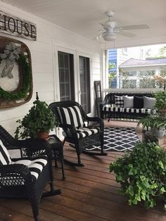 black and white striped chairs on a porch with potted plants in the foreground