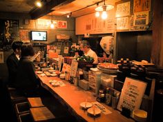 people are sitting at the counter in a restaurant