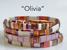 three different colored bracelets with the words olivia written in black on them