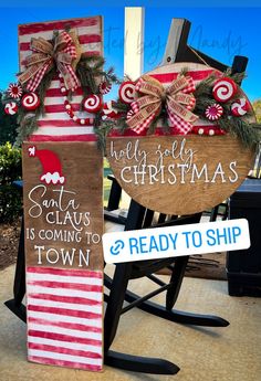 two wooden christmas signs sitting on top of a rocking chair