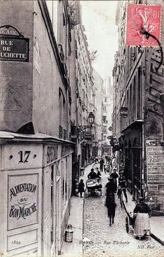 an old black and white photo of people walking down the street