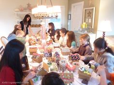 a group of people sitting around a table with boxes on it and plates in front of them