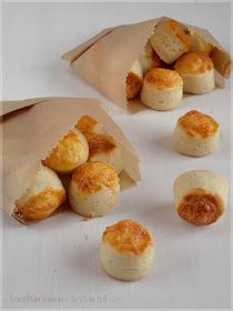 several small pastries sitting in a brown paper bag on a white surface with other food items scattered around them