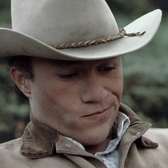 a man in a cowboy hat looking at the camera