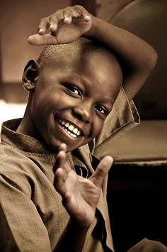 a young boy is smiling while sitting down